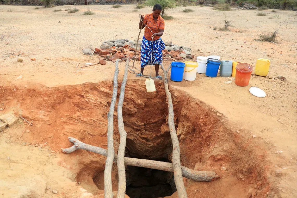 A woman fetches drinking water from an unprotected well in drought-stricken Zimbabwe.