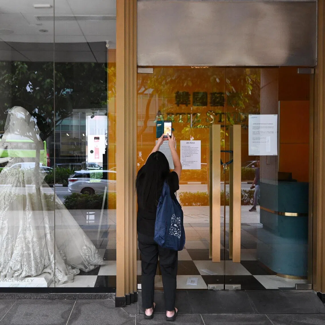 ST20260820-202616400647-Lim Yaohui-Daniel Lai-dlartiz20/
A woman taking photographs of Korea Artiz Studio at Carlton Hotel on Aug 20, 2026.
The space occupied by Korea Artiz Studio, which abruptly ceased operations over unpaid salaries, has been repossessed by Carlton Hotel.
A notice, dated Aug 20 and pasted on the doors of the studio, reads: “Please be informed that Carlton Hotel (Singapore) has repossessed these premises with effect from Aug 20.”
The hotel confirmed to The Straits Times on Aug 20 that it has taken back the premises.
Korea Artiz Studio abruptly ceased operations on Aug 14 over unpaid salaries. The Consumers Association of Singapore (CASE) said on Aug 19 that it received 66 complaints from the bridal store’s customers between Aug 14 and 18.
More than $271,000 in pre-payment losses were reported by customers after they failed to get a response from the business on whether contracted services would be fulfilled or if they could get a refund, said CASE.
(ST PHOTO: LIM YAOHUI)