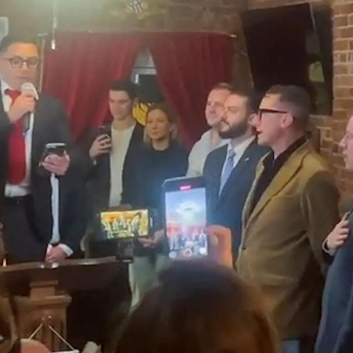 AfD lawmaker Jan Wenzel Schmidt (right) and fellow party members sing Germany, Germany Above All together with president of the New York Young Republican Club Stefano Forte (third from right), at a gathering in a Manhattan club.