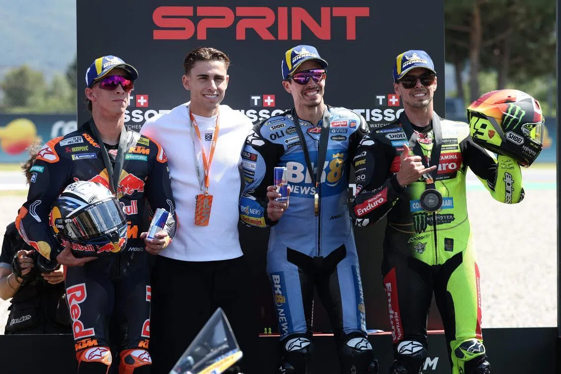 Second-placed KTM's Pedro Acosta (left), winner Gresini Racing's Alex Marquez (second from right) and third-placed VR46 Racing's Fabio di Giannantonio (right) on the podium with Barcelona's Spanish midfielder Fermin Lopez, after the sprint race at the Catalunya MotoGP Grand Prix in Montmelo, near Barcelona, on May 16, 2026.