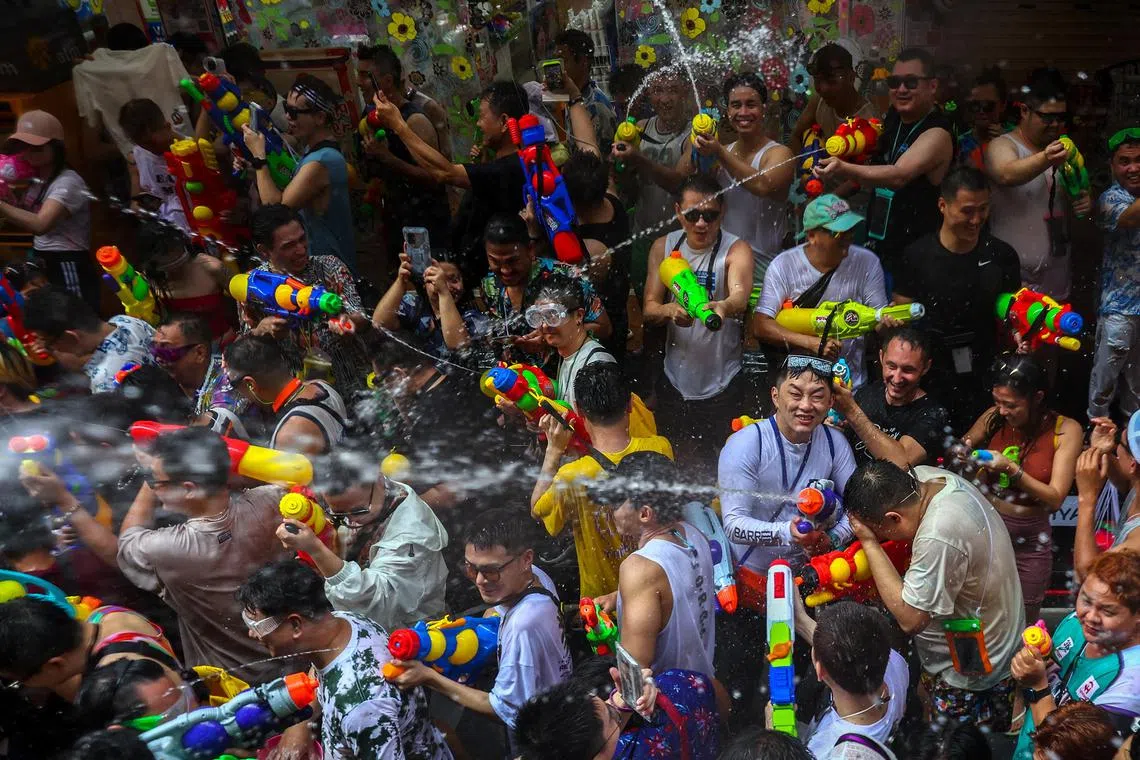 Locals and tourists play with water as they celebrate the Songkran holiday which marks the Thai New Year in Bangkok, Thailand, April 13, 2023. REUTERS/Athit Perawongmetha
