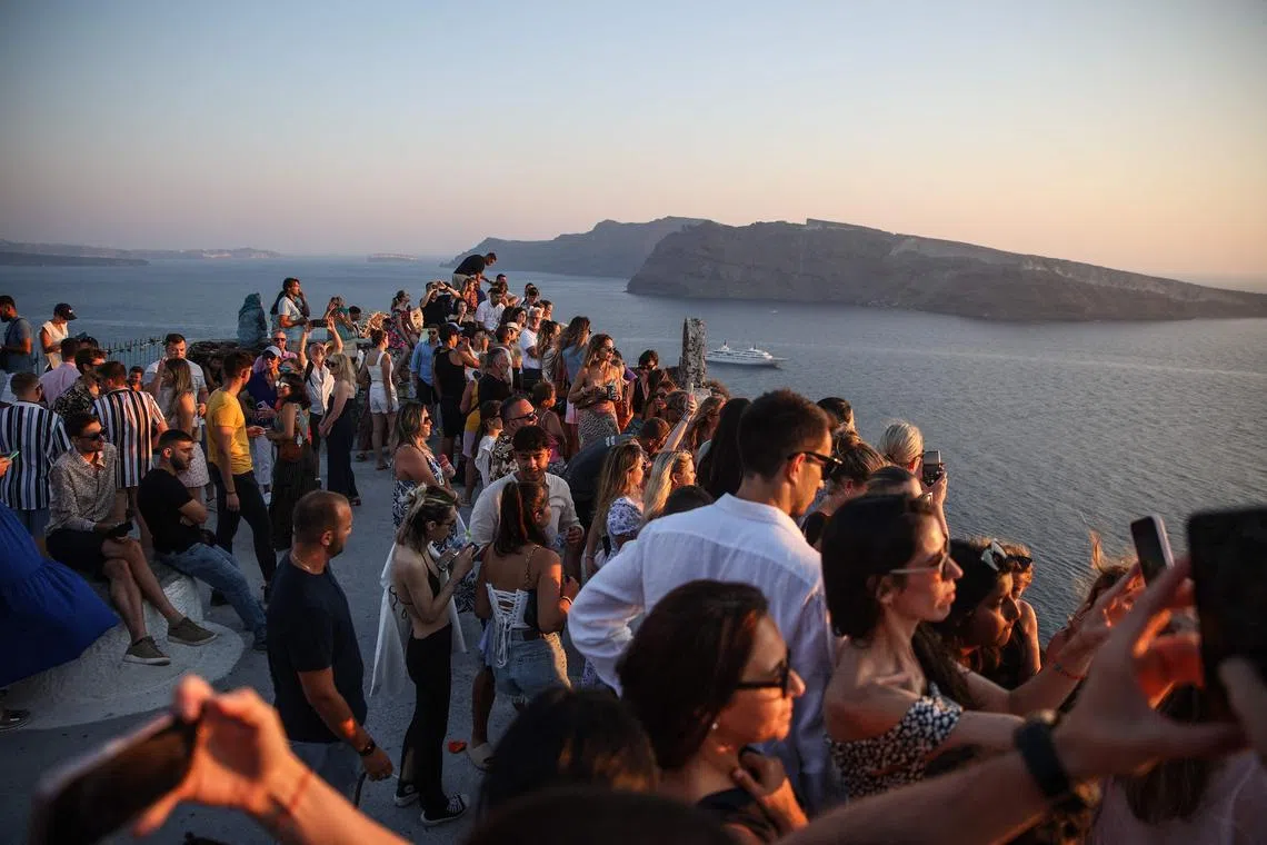 Tourists wait for the sunset in the village of Oia on the Greek island of Santorini on July 20.