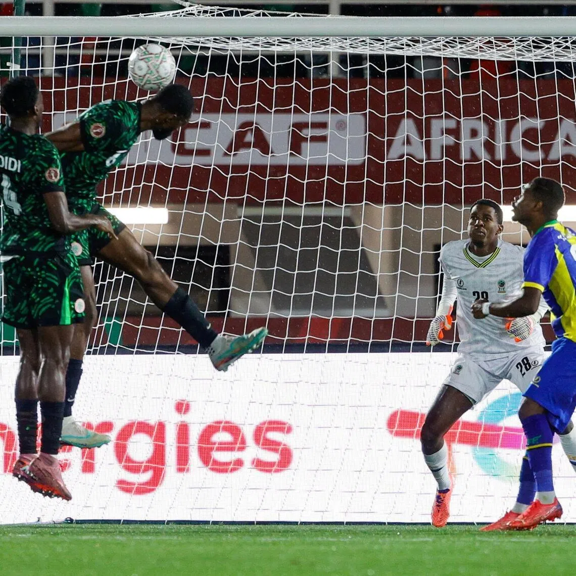 Nigerian defender Semi Ajayi (right) scores his team's first goal past Tanzania goalkeeper Zuberi Foba.