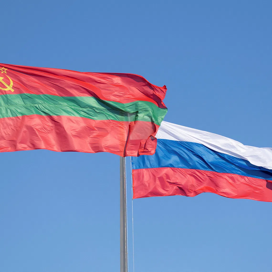 FILE PHOTO: Flags of Transdniestria and Russia fly in a square in Tiraspol, Moldova's breakaway region of Transdniestria, January 4, 2025. REUTERS/Vladislav Bachev/File Photo