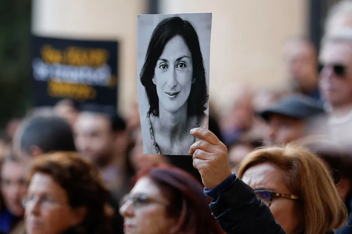 FILE PHOTO: A demonstrator holds up an image of assassinated journalist Daphne Caruana Galizia, during a protest in Valletta, Malta, February 16, 2025.  REUTERS/Darrin Zammit Lupi/File photo