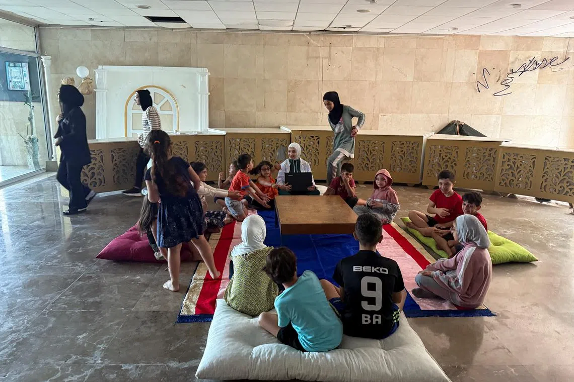 FILE PHOTO: Displaced people who fled from southern Lebanese villages, sit together at an out-of-service hotel turned into a shelter hosting them, due to ongoing hostilities between Hezbollah and Israeli forces, in Tripoli, north of Lebanon October 10, 2024. REUTERS/Walid Saleh/File Photo