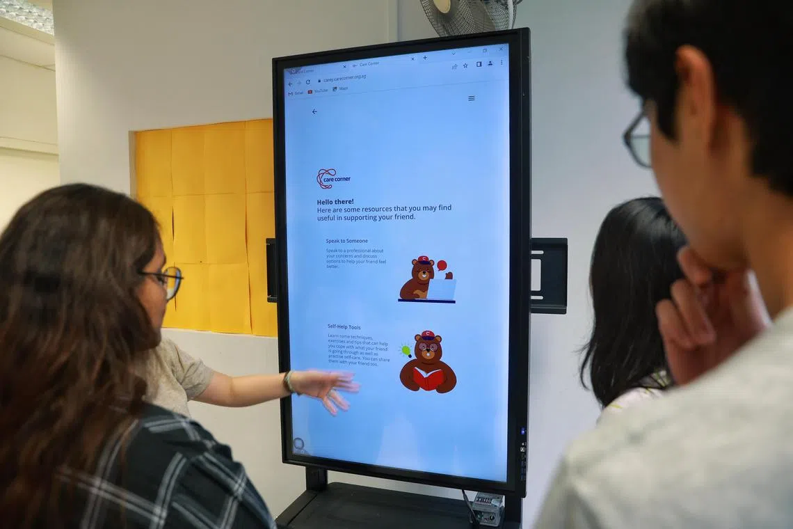 A 2023 file photo of a young woman being shown how to use Carey, a free online mental health buddy dedicated to youth and their caregivers.