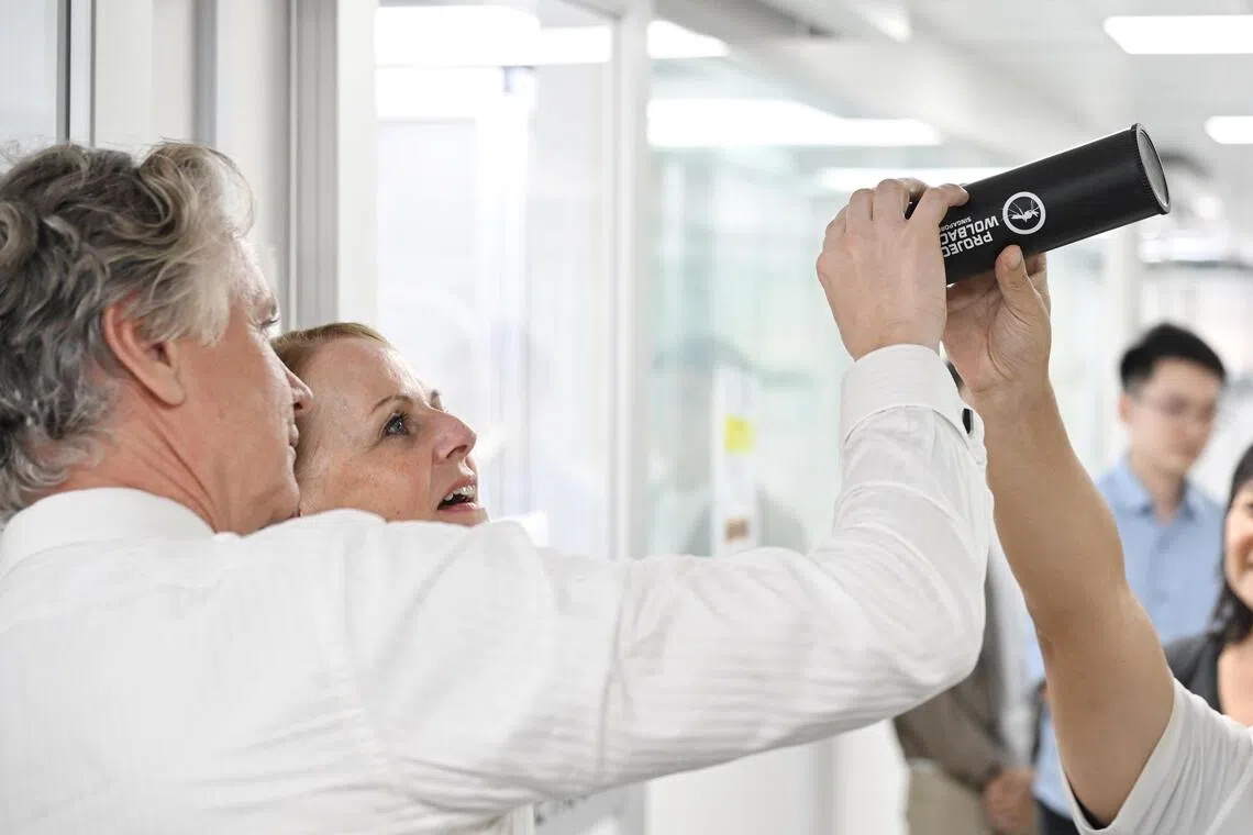 Florika Fink-Hooijer and Artis Bertulis looking at the Wolbachia mosquitos inside a mosquito launcher.