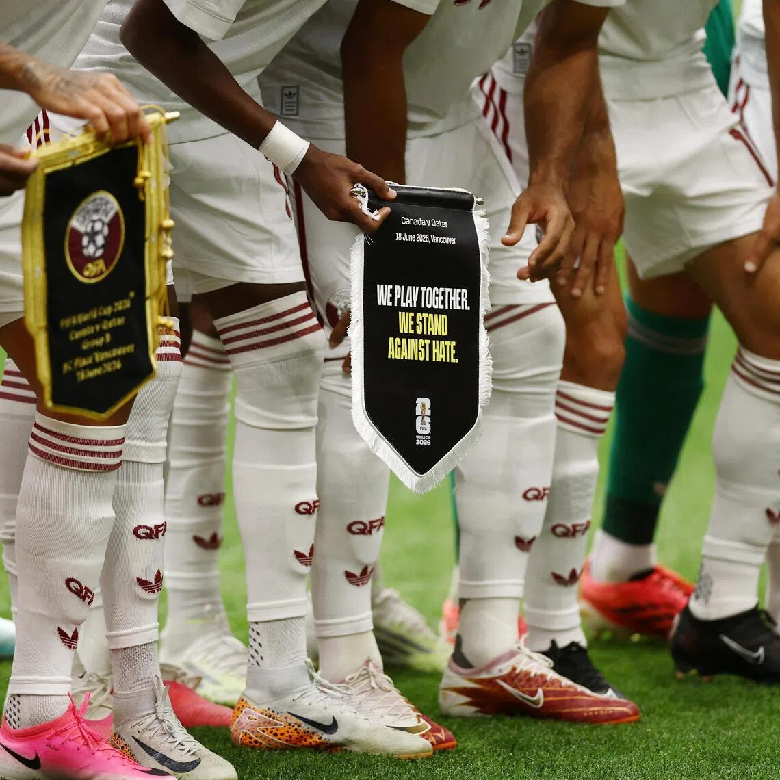 Players holding a pennant displaying an anti-racism message during the World Cup group match between Canada and Qatar on June 18.