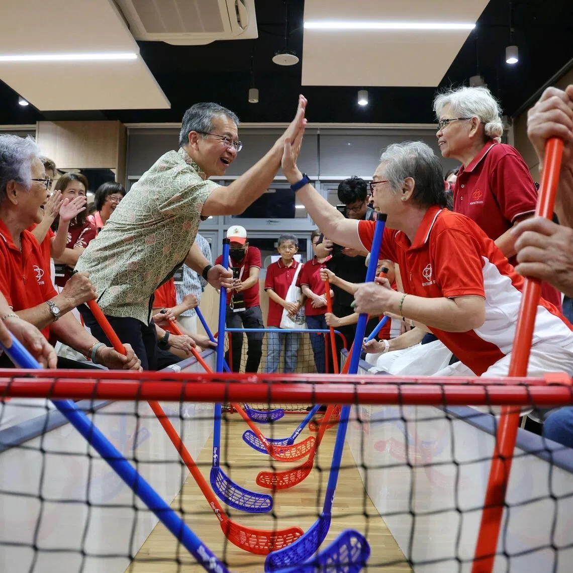 Law Minister Edwin Tong high-fiving Mountbatten resident Madam Tan How Khinn, 80, after their team scored a goal during a modified game of floorball with seniors at the launch of the new Mountbatten Community Club on April 4, 2026. ST PHOTO: KEVIN LIM zykaki04