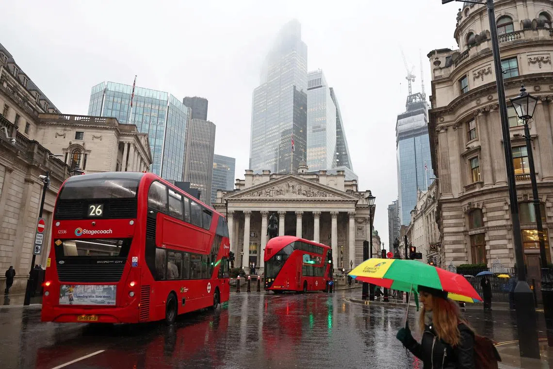 FILE PHOTO: Commuters walk as buses go past during the morning rush hour near the Bank of England in the City of London financial district in London, Britain, February 8, 2024. REUTERS/Toby Melville/File Photo