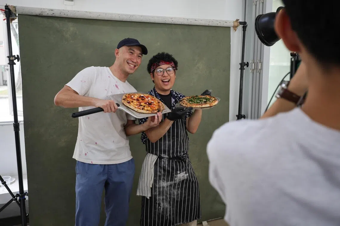 Abel Fam (left), community manager of The Chop Community, and Ngoh share a lighthearted moment at the pizza party they organised together. They served seven kinds of Neapolitan pizza that day.