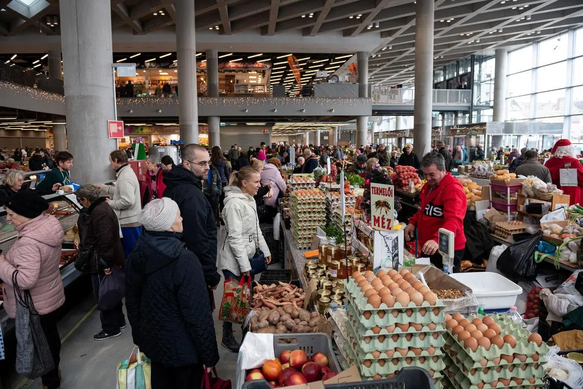 FILE PHOTO: People buy food at a market in Budapest, Hungary, December 3, 2022. REUTERS/Marton Monus/File Photo