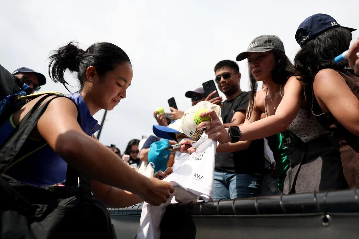 Even in defeat, Alexandra Eala of the Philippines stops to sign autographs for her legion of fans. 