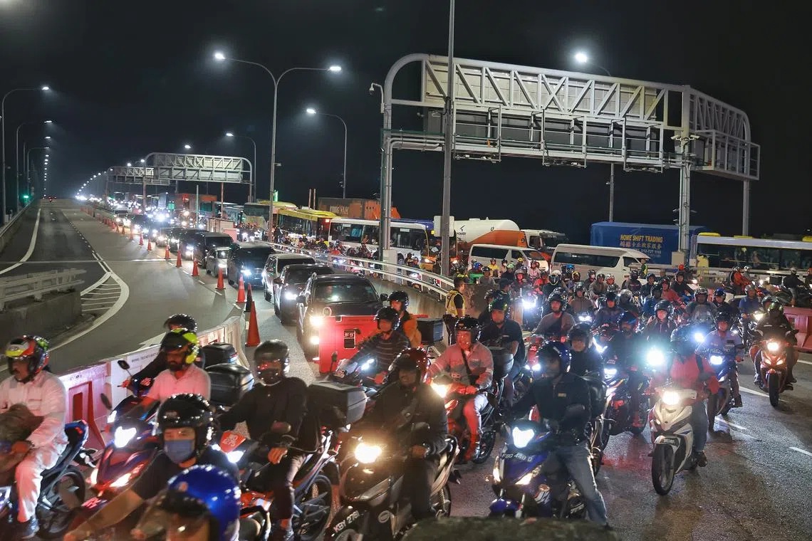 Arriving motorcyclists being diverted in waves towards the departure zone as part of ‘Operation Sunrise’ at Tuas Checkpoint on Aug 16.