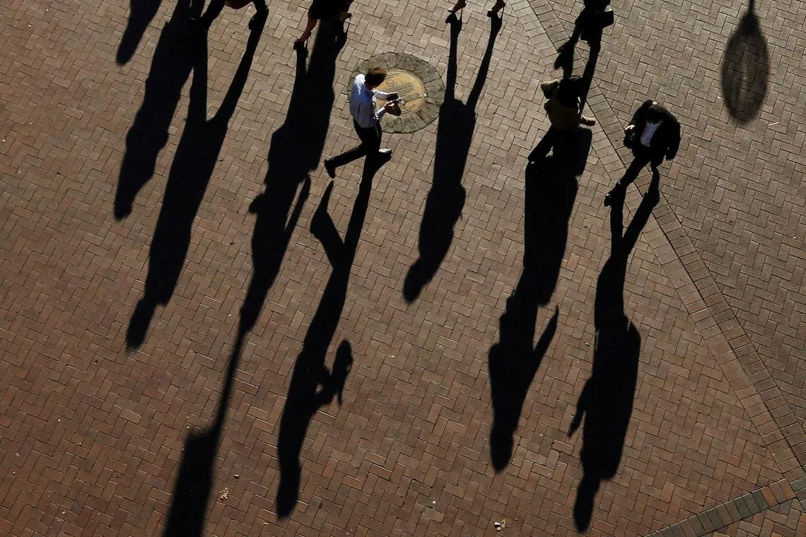 FILE PHOTO: Commuters cast their shadows as they arrive in the Central Business District during the morning rush hour in Sydney July 1, 2013.  REUTERS/Daniel Munoz/File Photo