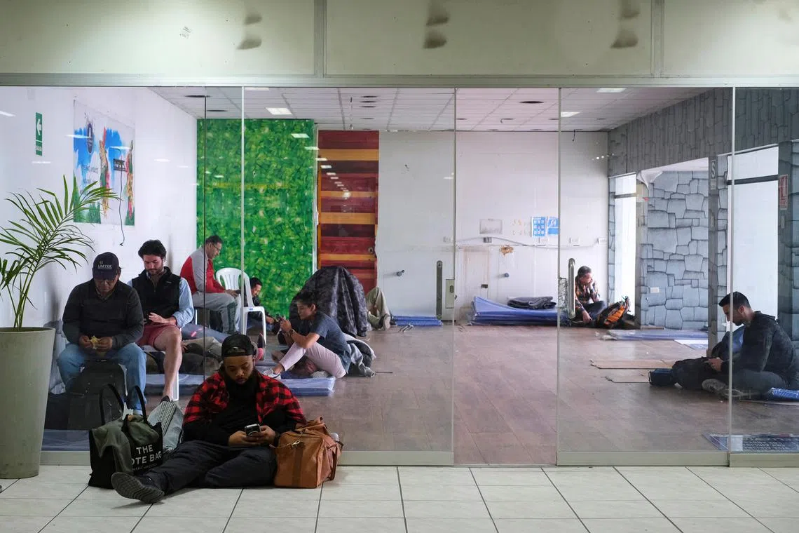 People rest on the floor as they wait for news about flights at the airport after it was closed due to protests sparked by the ousting of former President Pedro Castillo, in Cuzco, Peru December 16, 2022. REUTERS/Paul Gambin NO RESALES. NO ARCHIVES.