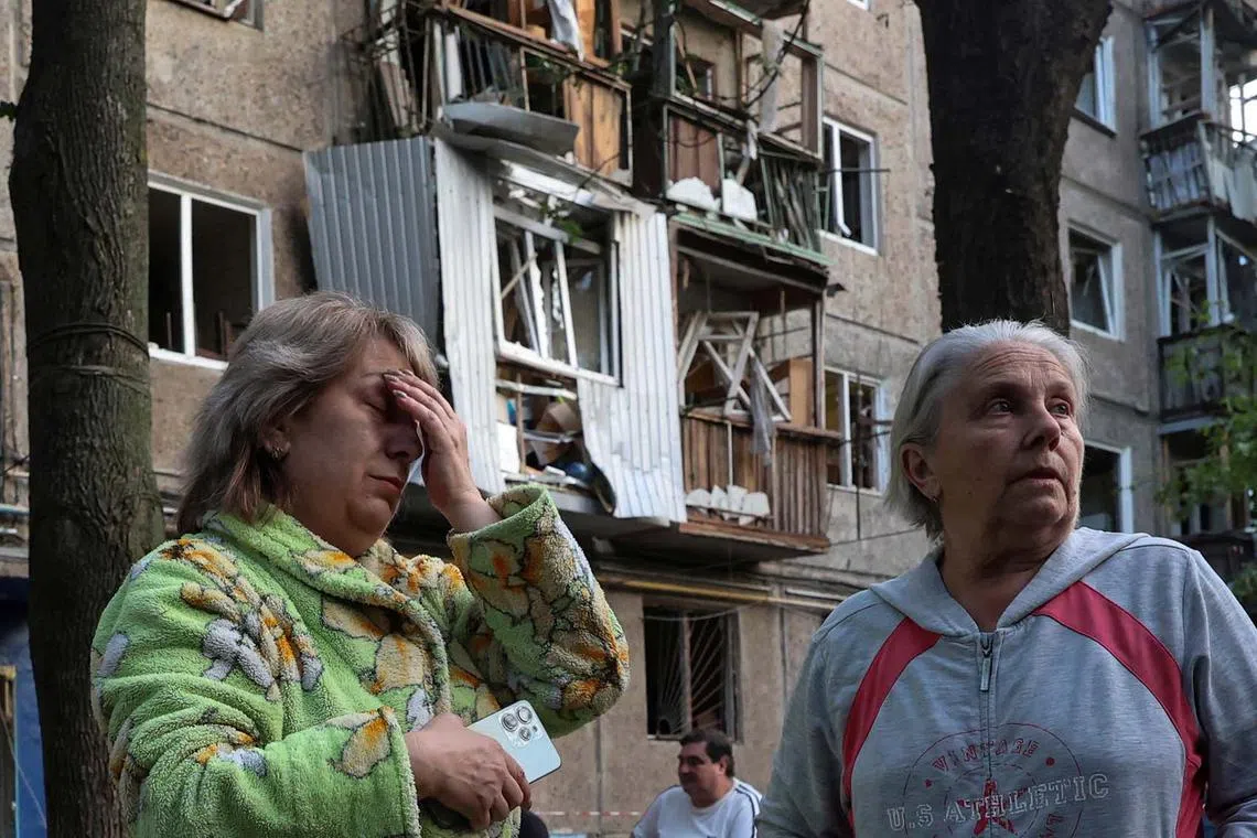 Women reacting next to their apartment building damaged by a Russian drone strike, amid Russia's attack on Ukraine, in Kharkiv, Ukraine, June 11, 2025. 