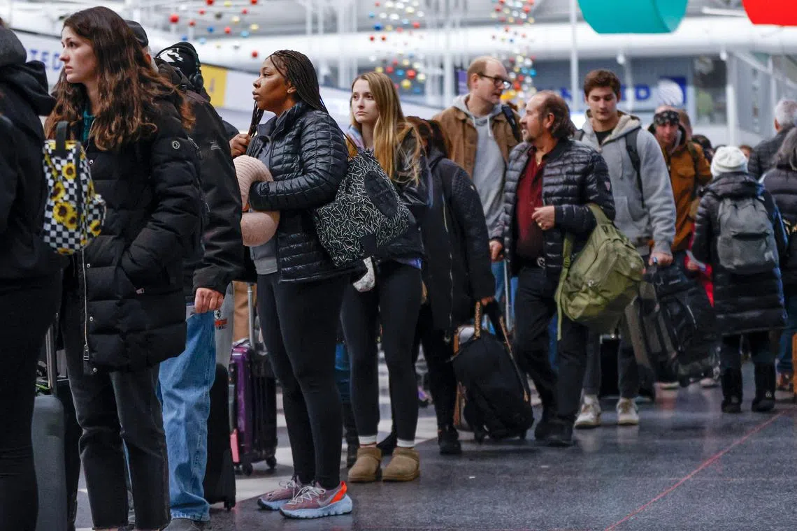 Travelers wait in line to check-in for their flights at the United Airlines Terminal 1 ahead of the Christmas Holiday at O'Hare International Airport on December 22, 2022, in Chicago. - US forecasters warned of life-threatening weather as a "once-in-a-generation" winter storm on Thursday threatened to wreak havoc on holiday travel plans for millions of Americans. The Federal Aviation Administration warned that high winds and heavy snow could delay flights at major air travel hubs Minneapolis-St. Paul, Chicago and Denver. (Photo by KAMIL KRZACZYNSKI / AFP)