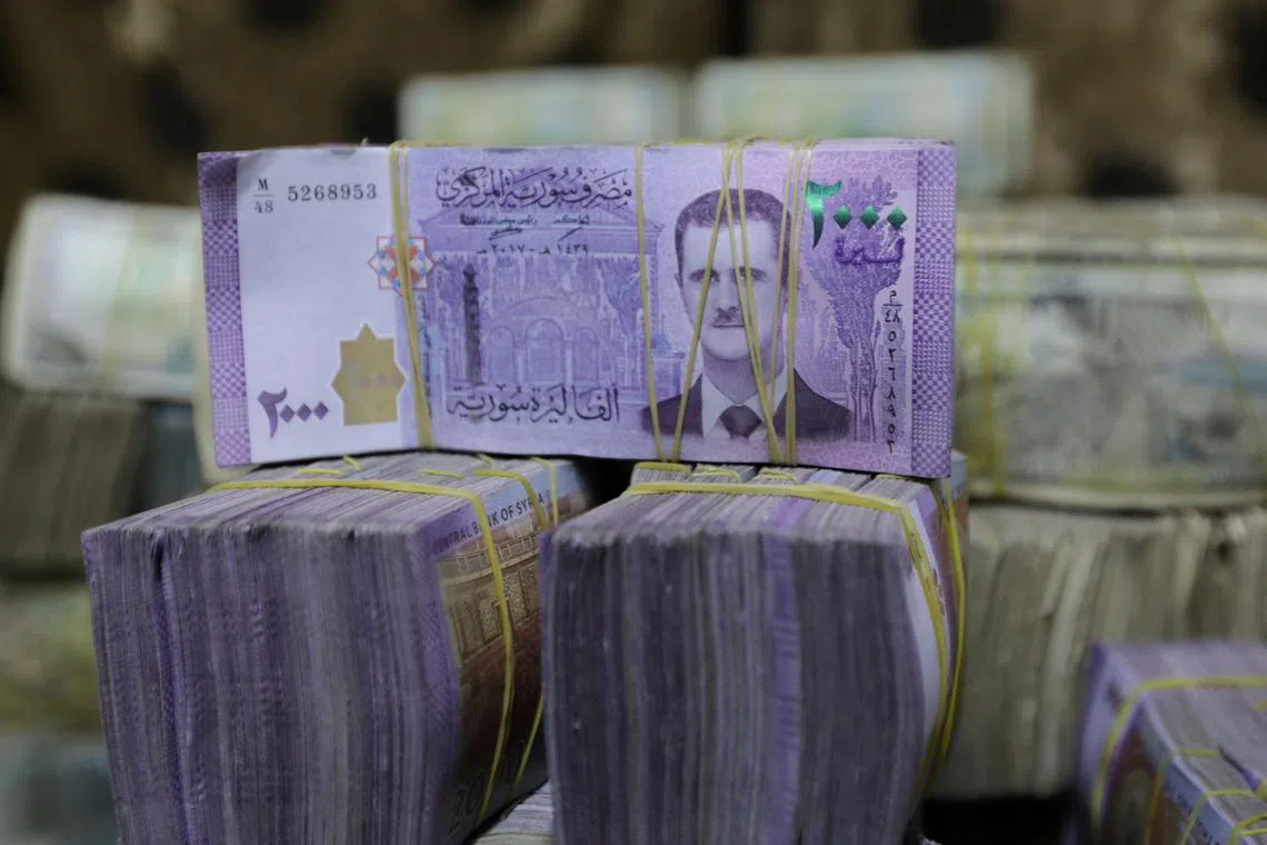 FILE PHOTO: Syrian pounds are pictured inside an exchange currency shop in Azaz, Syria February 3, 2020. Picture taken February 3, 2020. REUTERS/Khalil Ashawi/File Photo