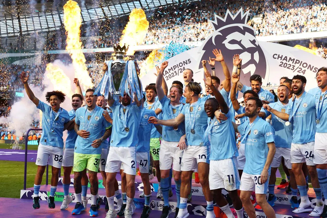 FILE PHOTO: Soccer Football - Premier League - Manchester City v West Ham United - Etihad Stadium, Manchester, Britain - May 19, 2024 Manchester City's Kyle Walker lifts the trophy on the podium and celebrates with teammates after winning the Premier League Action Images via Reuters/Lee Smith