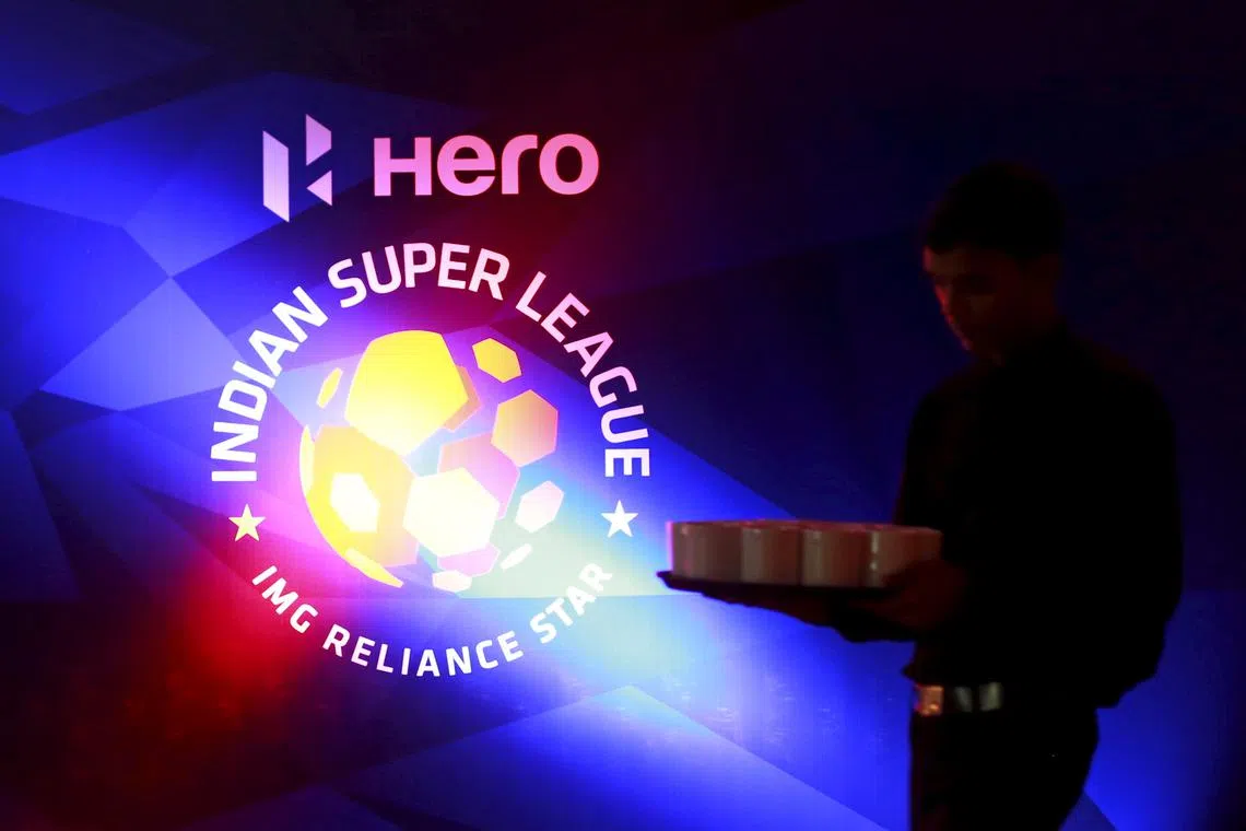 FILE PHOTO: A waiter walks past a logo of Indian Super League before a news conference during the domestic player auction and draft in Mumbai, India, July 10, 2015. India's most prolific goal-scorer Sunil Chhetri drew the highest bid in Friday's auction and will join former France striker Nicholas Anelka at the Mumbai FC in the second edition of the Indian Super League (ISL). REUTERS/Danish Siddiqui/File Photo