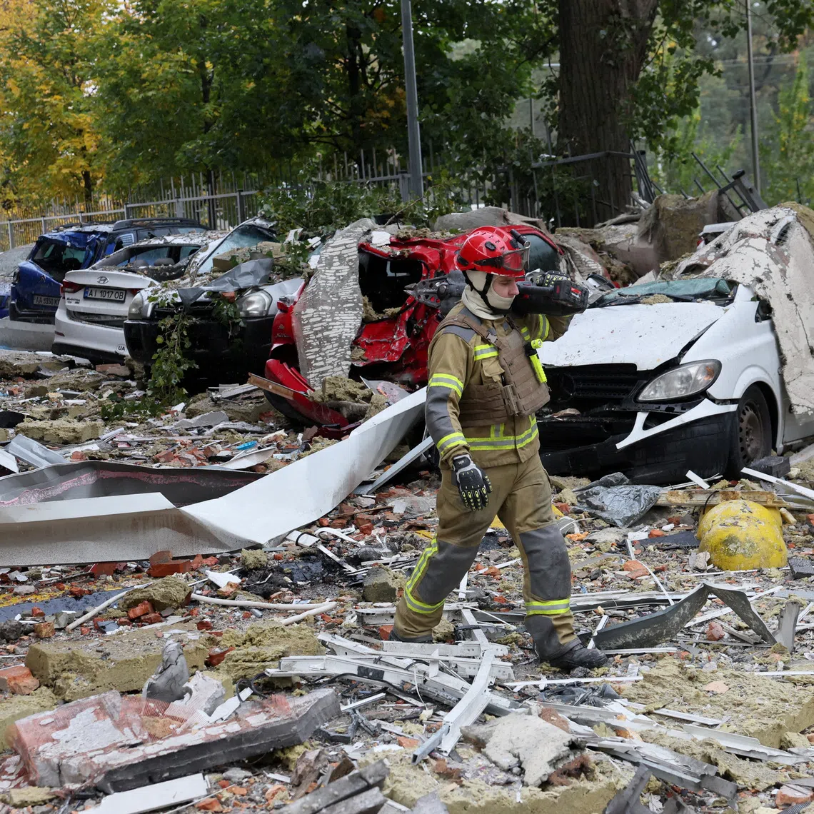First responders walk on debris at the site of an apartment building, which was damaged during a Russian drone strike, amid Russia's attack on Ukraine, in Kyiv, Ukraine, October 21, 2026. REUTERS/Gleb Garanich