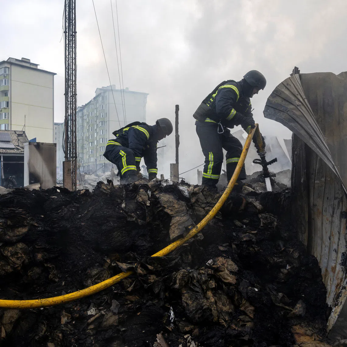 Emergency responders work at the site of a warehouse that was struck during a night of Russian missile and drone strikes, amid Russia's attack on Ukraine, in Novi Petrivtsi, outside Kyiv, Ukraine, December 6, 2025. REUTERS/Thomas Peter