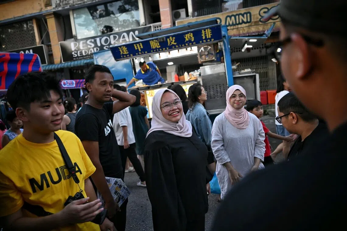 (In black) Muda's president Amira Aisya and Muda's Puteri Wangsa candidate, Rashifa Aljunied, at a walkabout at Pelangi Indah nightmarket, on Jun 28, 2026.