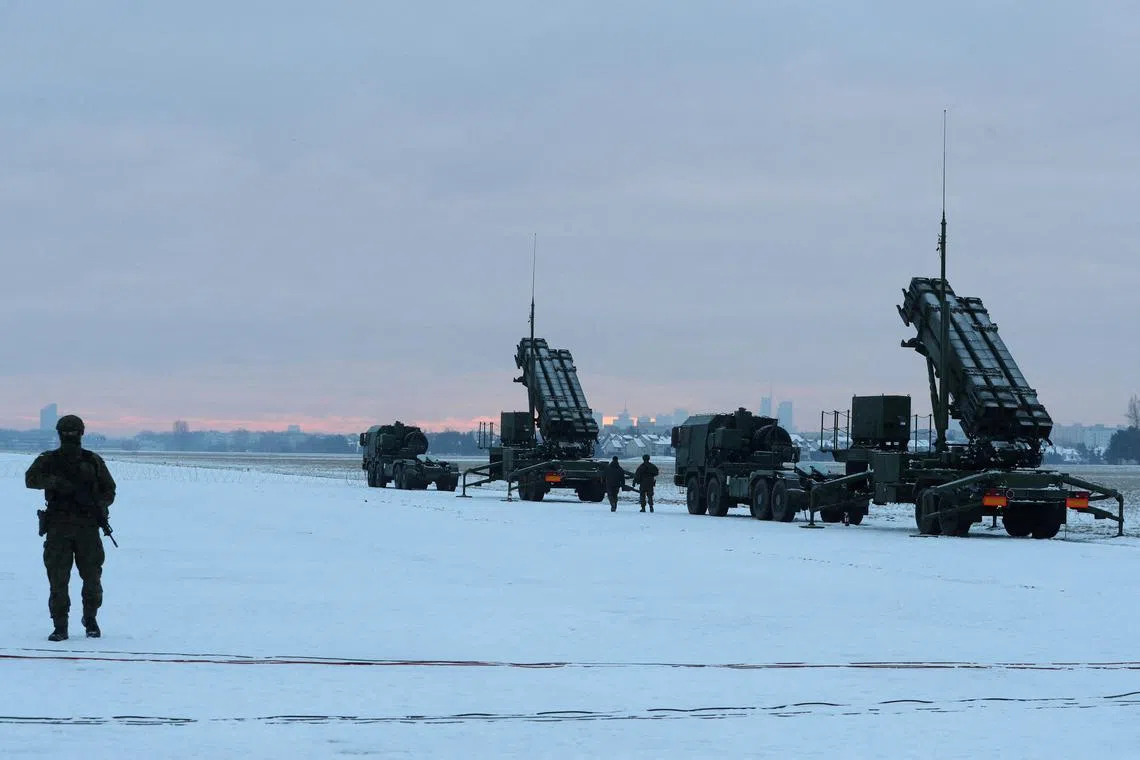 FILE PHOTO: Serviceman patrols in front of the Patriot air defence system during Polish military training on the missile systems at the airport in Warsaw, Poland February 7, 2023. REUTERS/Kacper Pempel/File Photo
