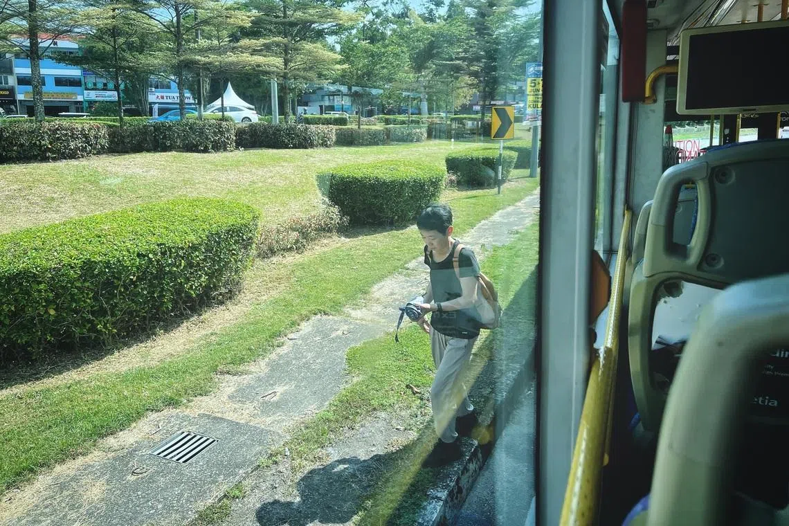 A passenger disembarking at an unmarked bus stop along Jalan Dato Jaafar near the busy Jalan Kebun Teh area in Johor Bahru on June 4.