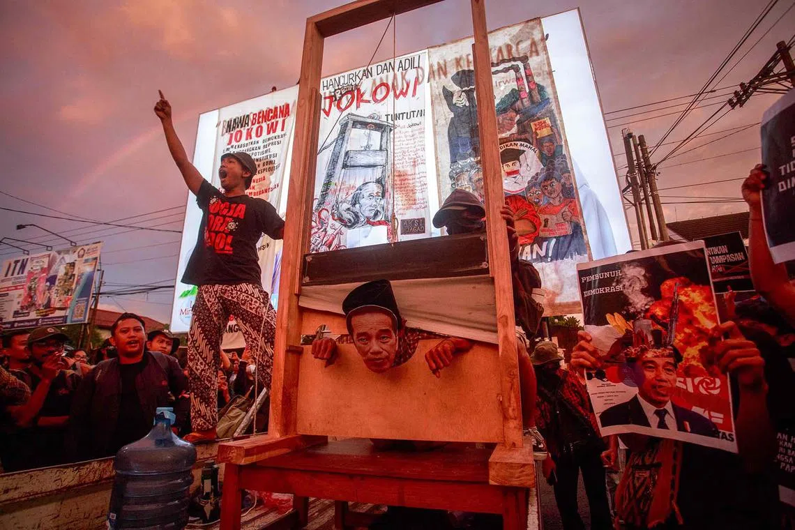 TOPSHOT - A student wearing a mask of Indonesia’s President Joko Widodo performs with a guillotine as hundreds of students protest against his family's political dynasty in the 2024 elections in Yogyakarta, on February 12, 2024. (Photo by DEVI RAHMAN / AFP)