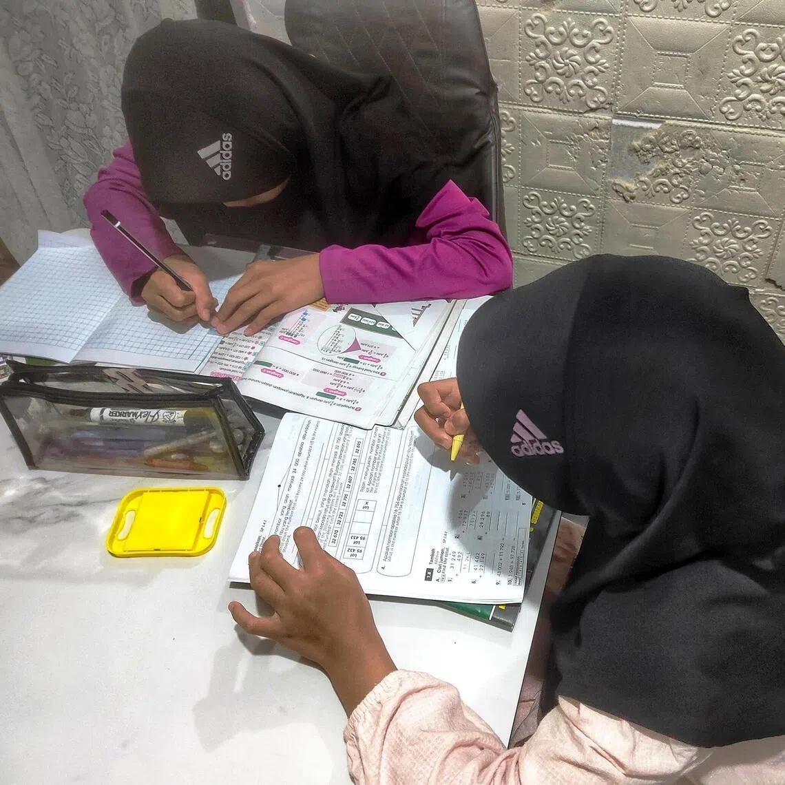 Two of 
Ms Mas Amirah Yaacob's
children doing their homework on a weeknight,