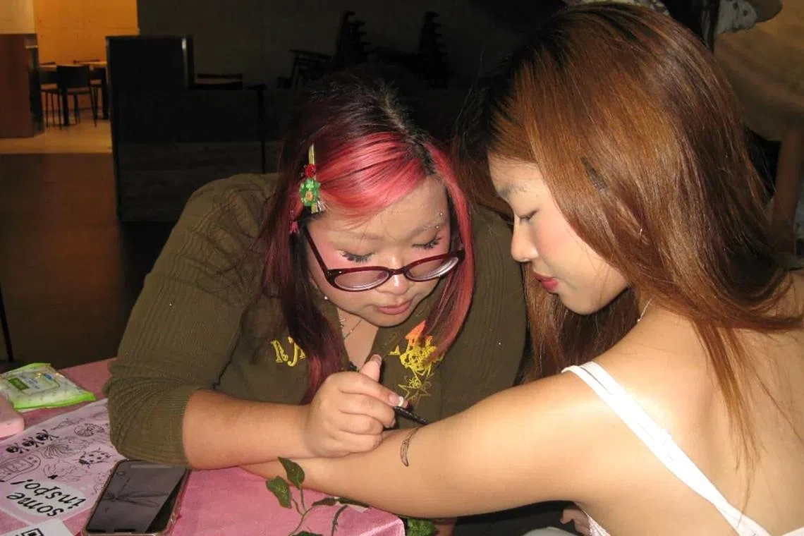 Nikita Ria Jei Siregar, 21, draws a jagua tattoo on a customer’s arm at Hammock Market on April 4.