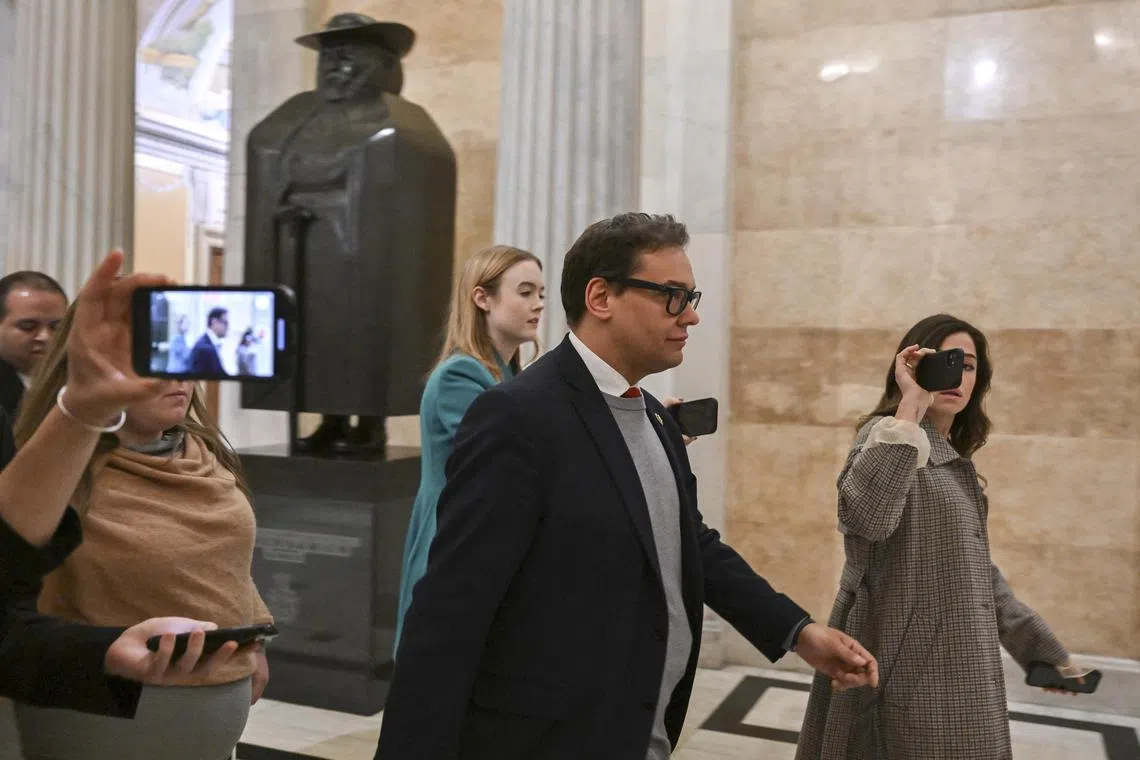 Republican Representative George Santos is surrounded by reporters as he walks through the US Capitol building, on Jan 6, 2023.