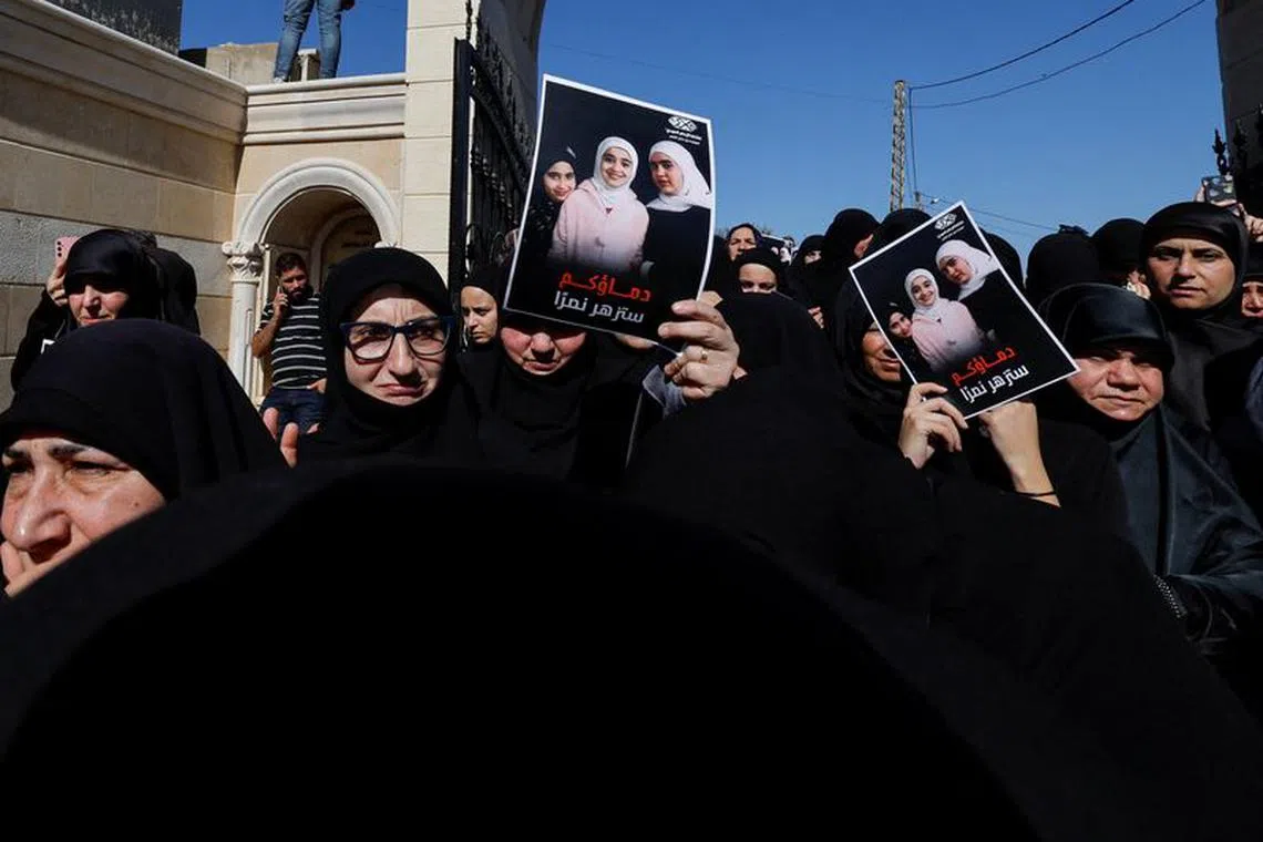 Mourners hold photographs of three Lebanese girls who were killed along with their grandmother in what Lebanese authorities said was an Israeli strike that hit their car on Sunday, as they mourns during their funeral, in the southern town of Blida, Lebanon November 7, 2023. REUTERS/Zohra Bensemra