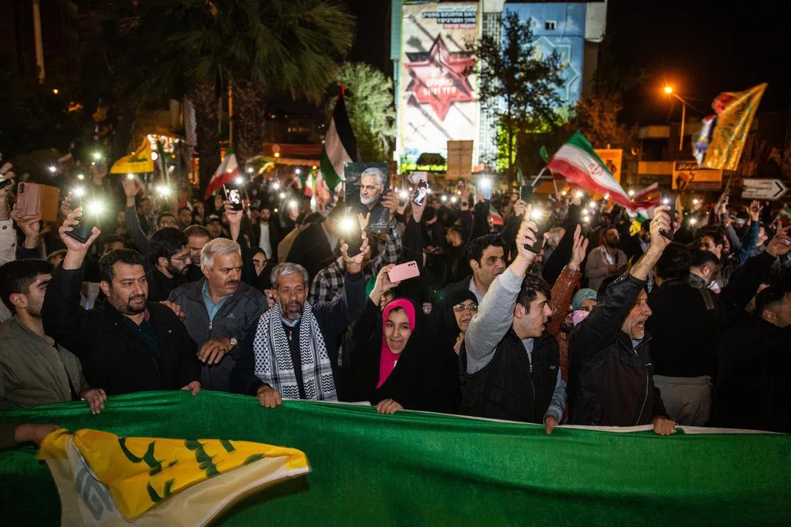Iranian demonstrators show support during an anti-Israeli gathering at Palestine Square in Tehran, early on April 14.