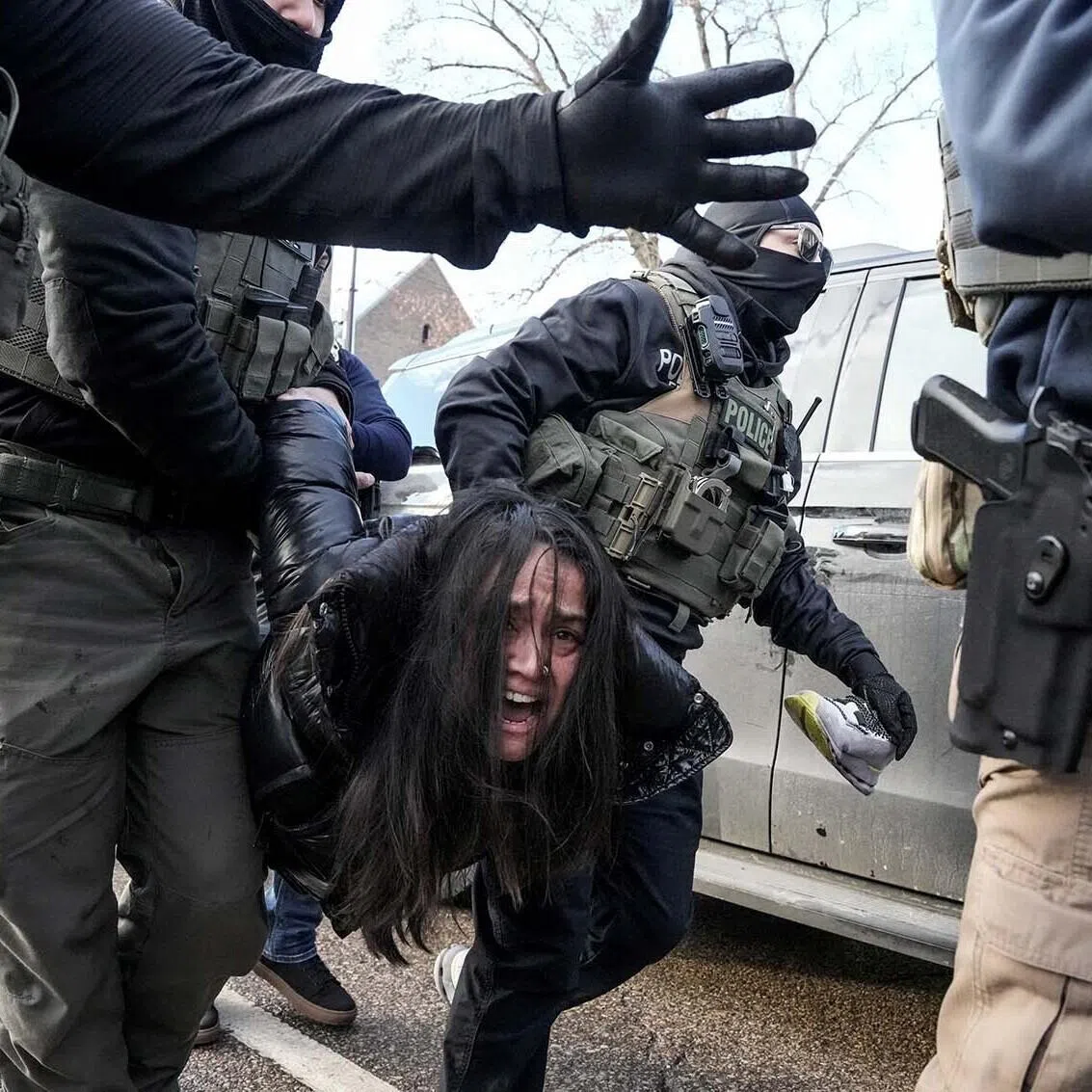 Federal agents carry away a woman, days after an ICE agent fatally shot Ms Renee Nicole Good, in Minneapolis.