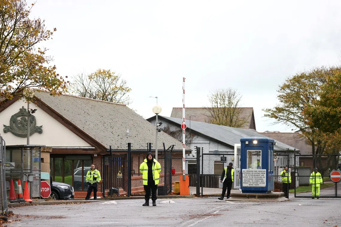 Security guards stand at the entrance to a migrant processing centre in Manston, Britain, November 3, 2022. REUTERS/Henry Nicholls