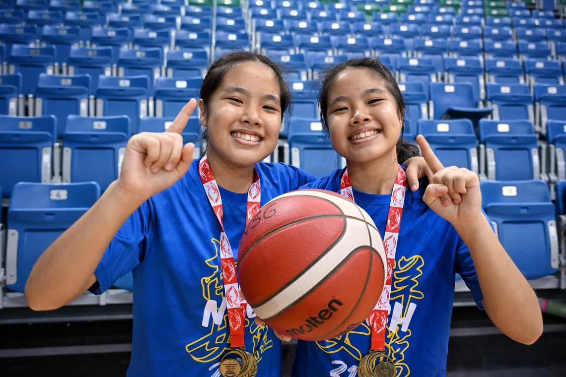 Jovia (left) and Jovie Teo combined to lead Nanyang Girls' High School to their second straight C Division basketball title.