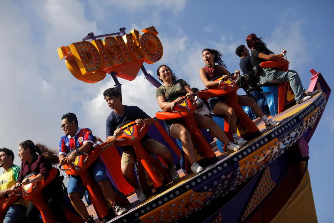 Visitors enjoying a ride in a fair during the festivities of El Divino Salvador del Mundo (The Divine Savior of the World), in San Salvador, El Salvador, on Aug 7, 2025. 