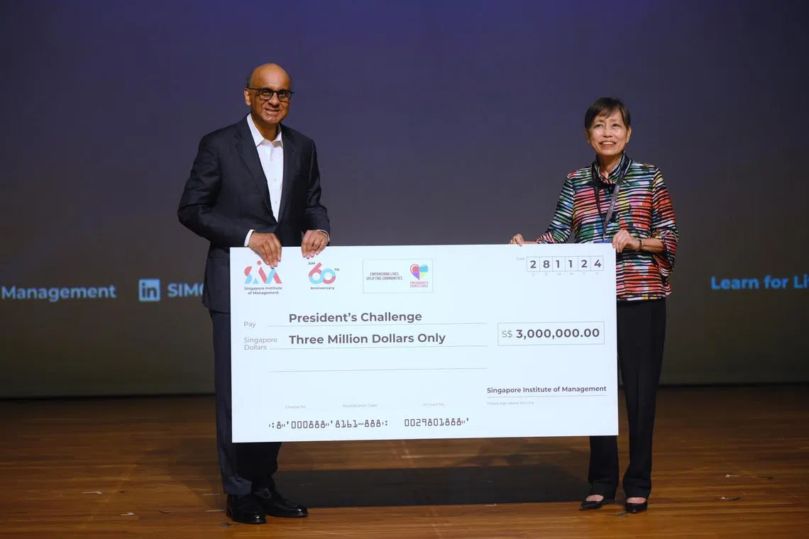 Ms Euleen Goh (right), Chairman of Singapore Institute of Management (SIM), hands a mock cheque on behalf of SIM to President Tharman Shanmugaratnam who is receiving on behalf of the President?s Challange, during the SIM60 Learning Festival on Nov 28, 2024.