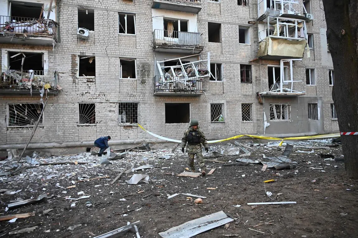A rescuer works outside a residential building damaged as a result of Russian strikes in Kharkiv, on March 27.