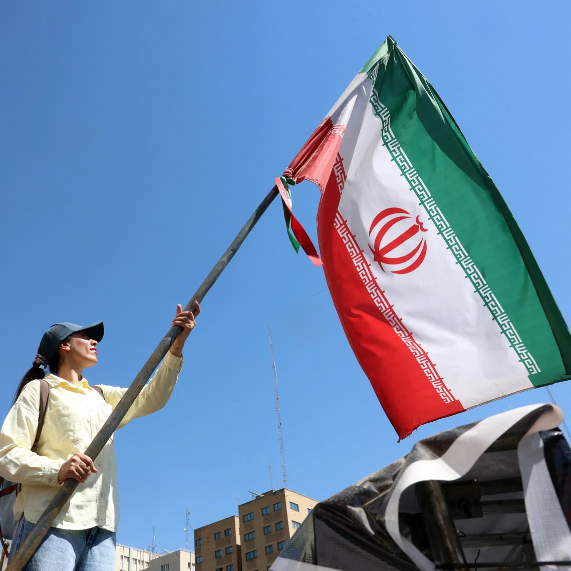 A woman waving the Iranian national flag at Valiasr Square in central Tehran, Iran.