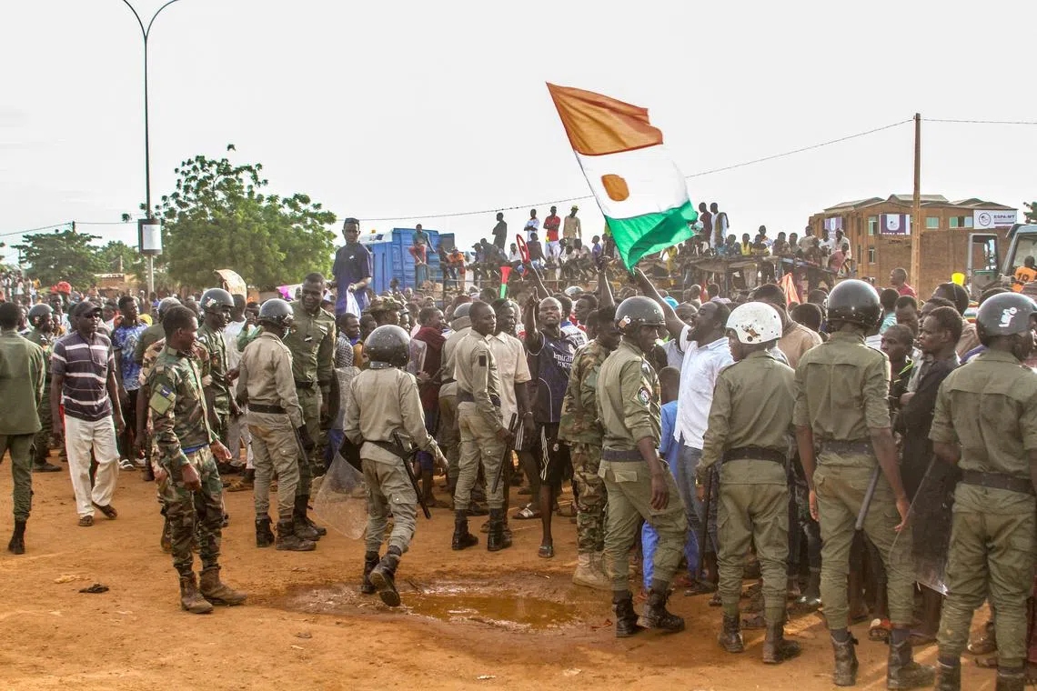 Niger's junta supporters take part in a demonstration in front of a French army base in Niamey.