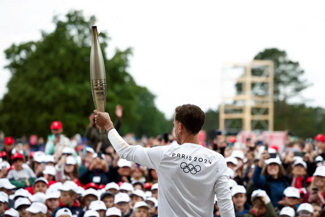FILE PHOTO: Torchbearer Nicolas-Marie Daru holds the Olympics torch during the relay ahead of the Paris 2024 Olympic games, at the World War II Normandy American Cemetery and Memorial, in Colleville-sur-Mer, situated above Omaha Beach, Normandy region, France, May 30, 2024. REUTERS/Benoit Tessier/File Photo