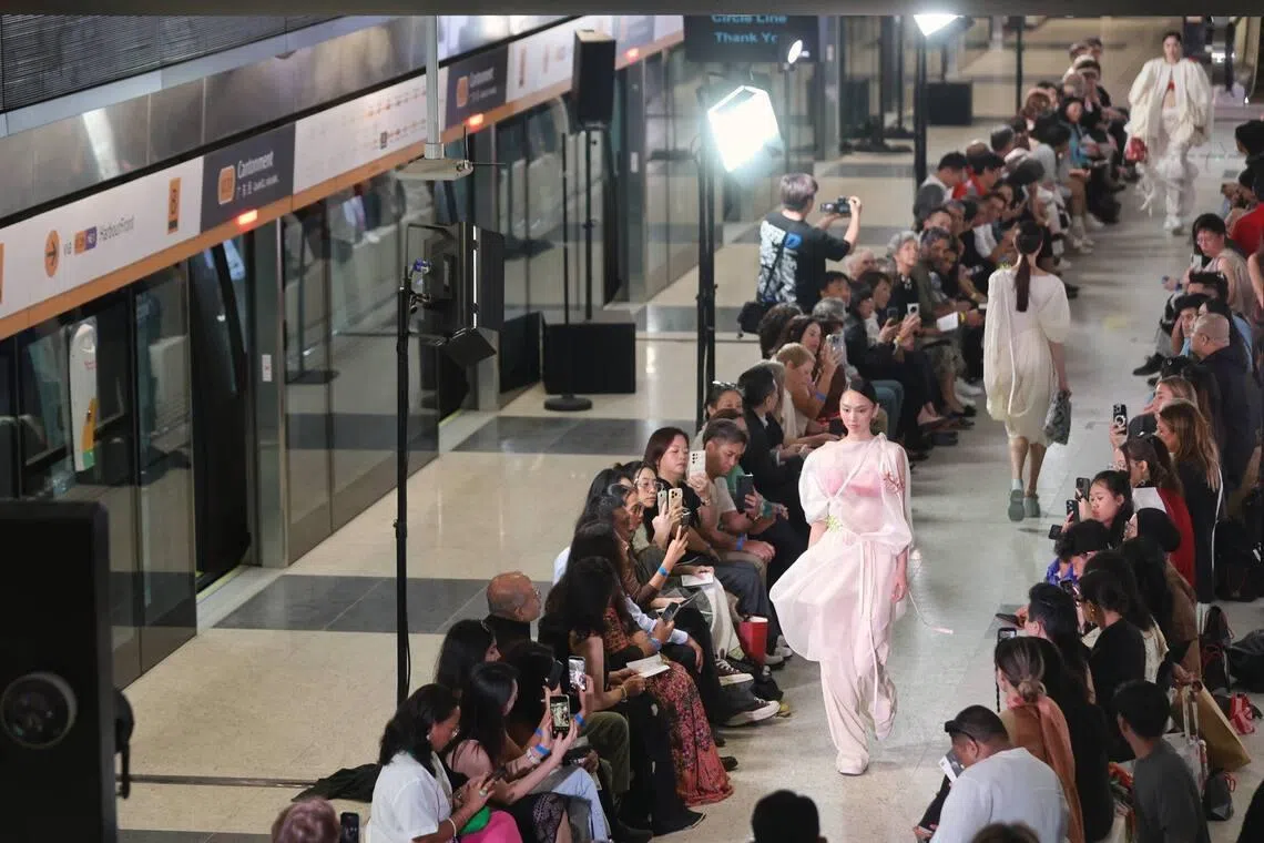 Models walk down a runway set up along the platform of the upcoming Circle Line Cantonment MRT station during the LASALLE College of the Arts’ graduate fashion show “DE:CENTERING” on May 14.