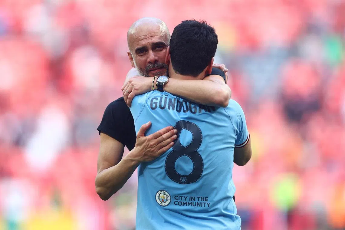 FILE PHOTO: Soccer Football - FA Cup Final - Manchester City v Manchester United - Wembley Stadium, London, Britain - June 3, 2023 Manchester City manager Pep Guardiola and Ilkay Gundogan celebrate after winning the FA Cup REUTERS/Carl Recine
