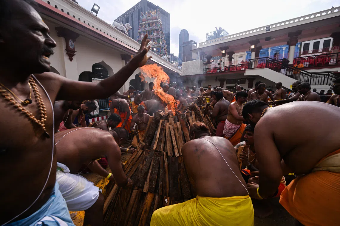 Devotees adding firewood to the first batch of firewood to ensure a steady fire. 