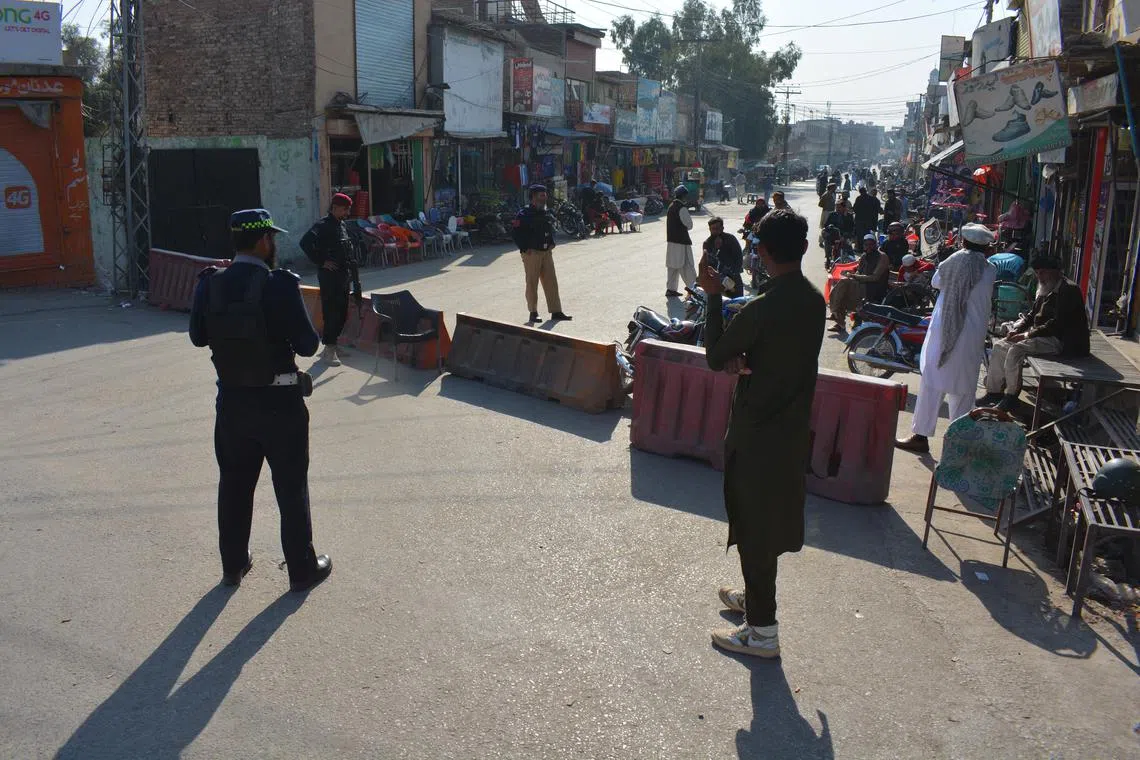 Pakistani security officials stood guard outside the entrance to Bannu Cantt area where militants seized a counter-terrorism department facility in Bannu, KPK province, Pakistan, on Dec 20, 2022.. 